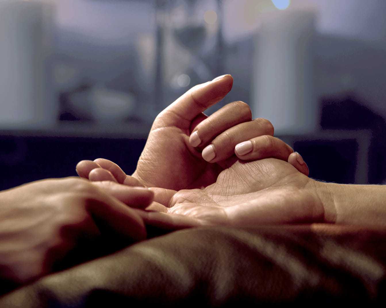 Two people holding hands gently, conveying support and connection.